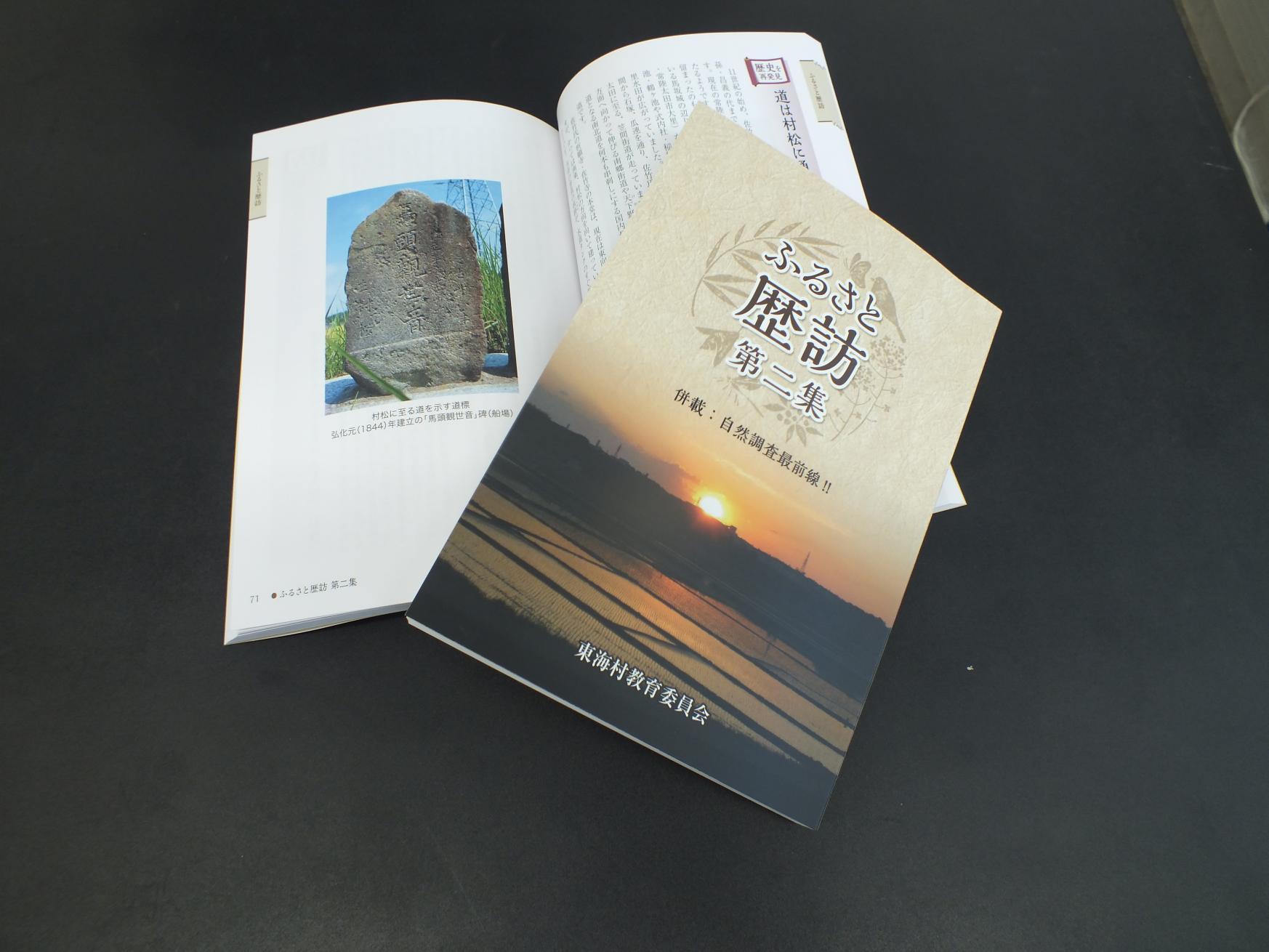 石碑のページを開いた本の上に重ねた、ふるさと歴訪第二集の表紙の写真