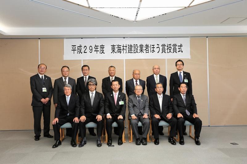 東海村建設業者ほう賞授賞式で、前列に6人、後列に7人のスーツ姿の男性の集合写真