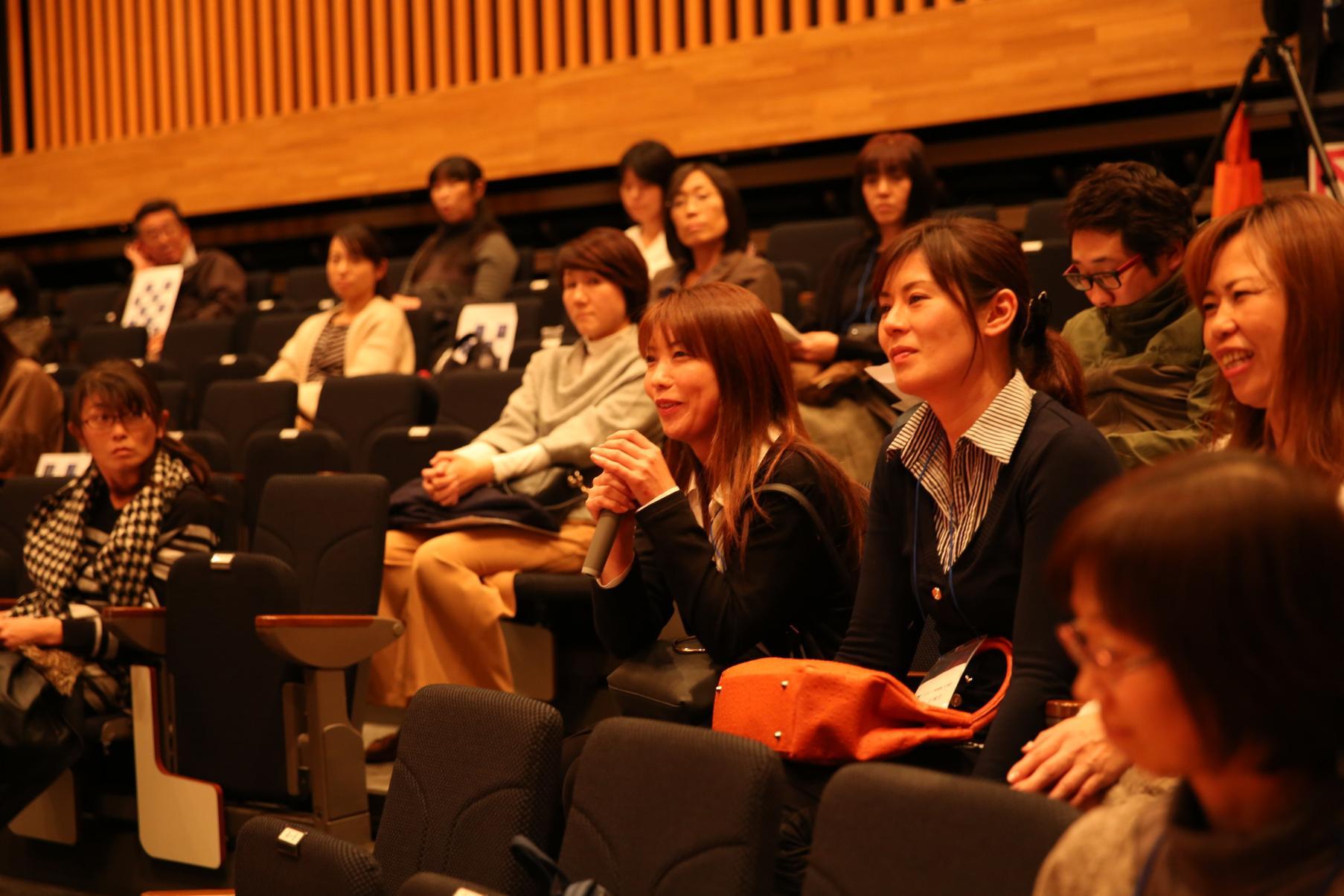 座席に座り講演を聞く、研修生たち参加者の写真