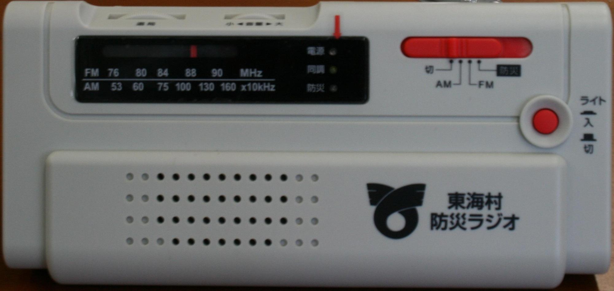 白い本体にライトのオン・オフボタンと、ラジオの切り替えスイッチ・チューニングダイヤルが付いた防災ラジオの写真