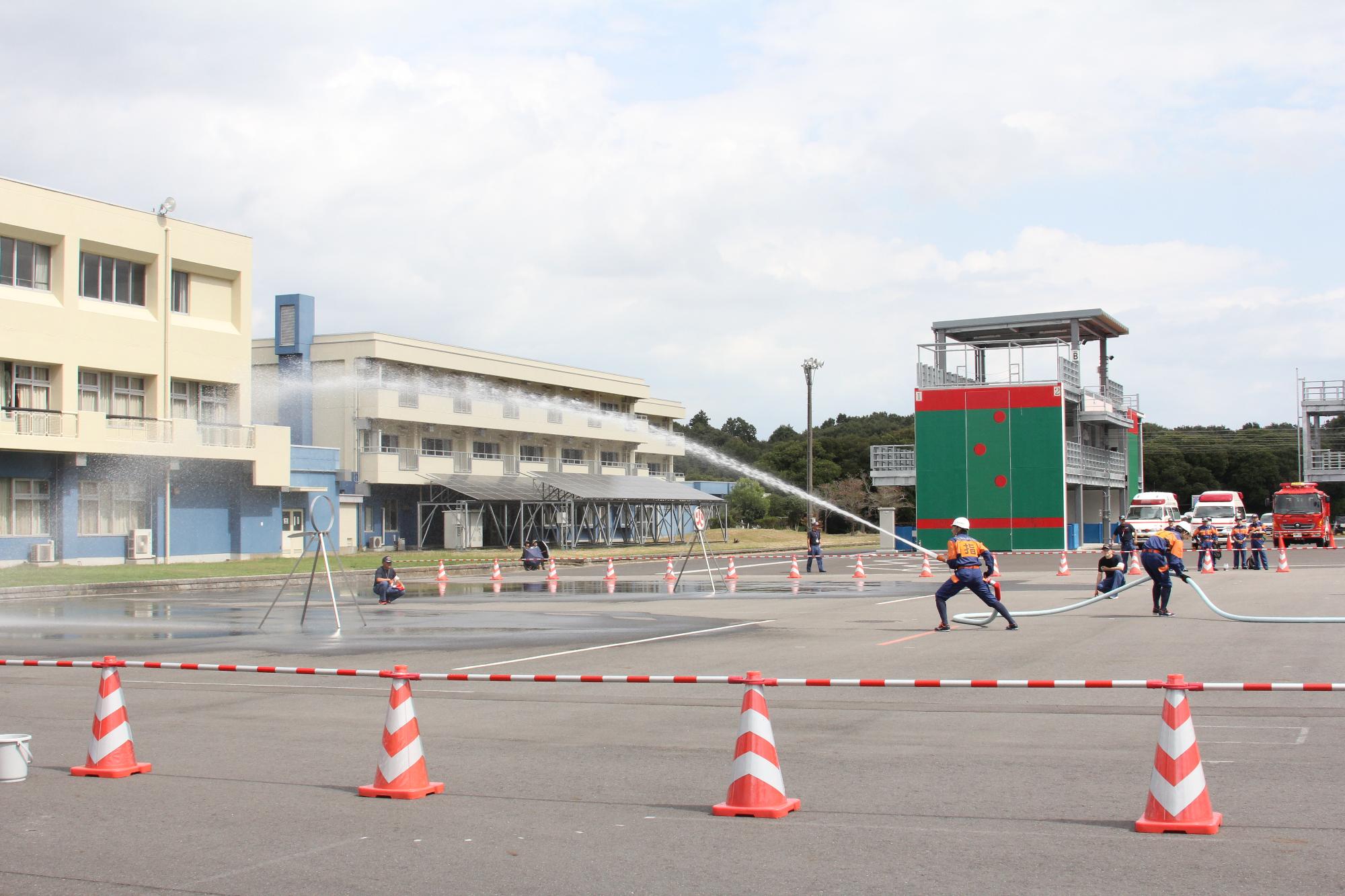 消防ポンプ操法大会で、ホースを持って放水している消防団員の写真